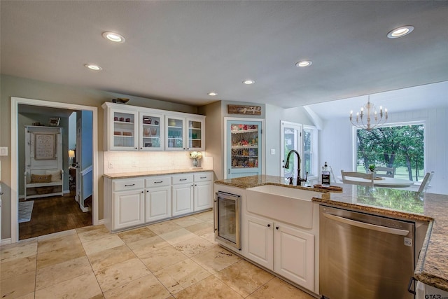 kitchen featuring beverage cooler, dishwasher, white cabinetry, sink, and a notable chandelier