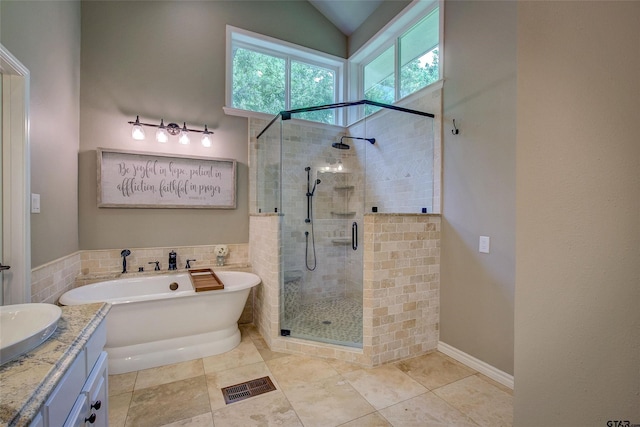 bathroom with shower with separate bathtub, vanity, and vaulted ceiling