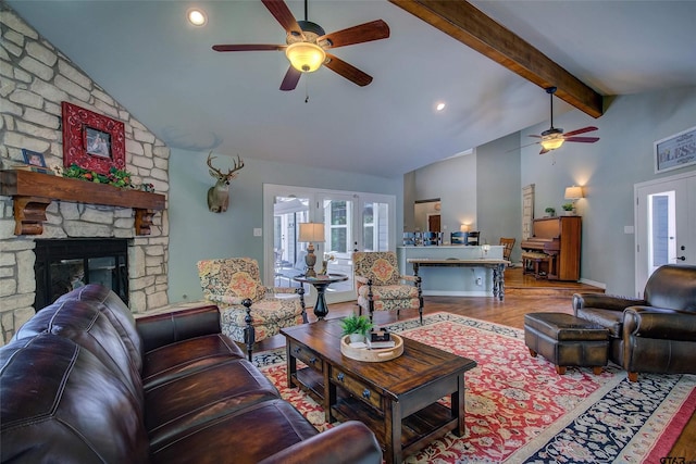 living room featuring lofted ceiling with beams, french doors, a stone fireplace, and wood-type flooring