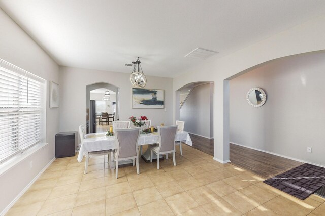 dining room with a notable chandelier and light tile patterned floors