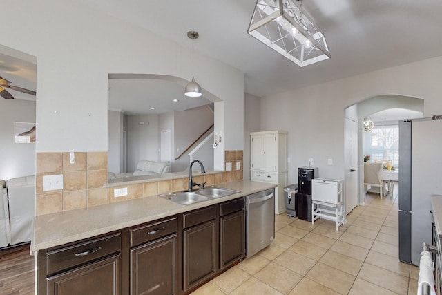 kitchen with appliances with stainless steel finishes, pendant lighting, sink, ceiling fan, and dark brown cabinetry