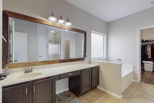 bathroom featuring tile patterned flooring, vanity, and a tub to relax in