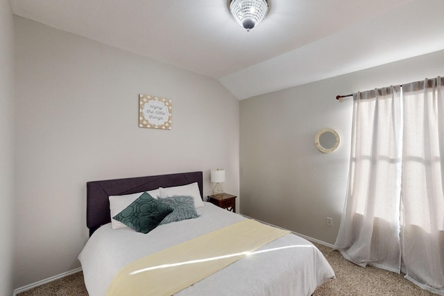 bedroom with carpet floors and vaulted ceiling