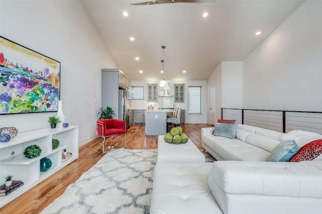 living room featuring ceiling fan and light hardwood / wood-style flooring