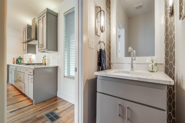 bathroom featuring vanity, backsplash, and hardwood / wood-style floors