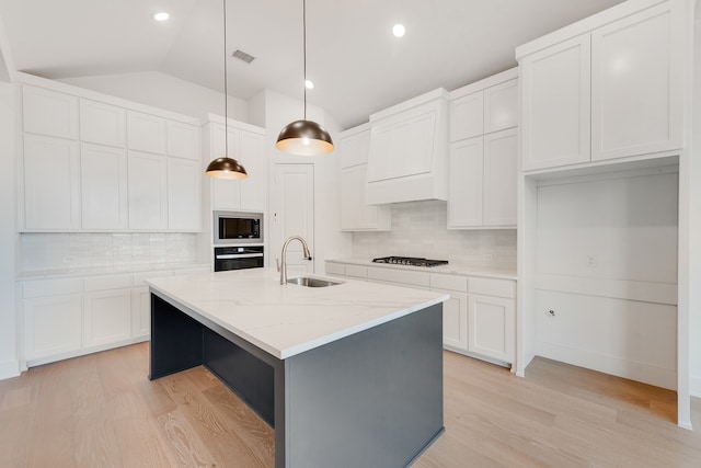 kitchen featuring a center island with sink, sink, pendant lighting, white cabinets, and black appliances