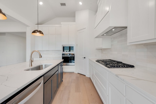 kitchen with white cabinets, stainless steel appliances, sink, hanging light fixtures, and light stone counters