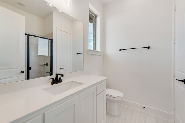 bathroom with walk in shower, vanity, and toilet