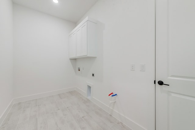 clothes washing area with hookup for a washing machine, cabinets, gas dryer hookup, and electric dryer hookup