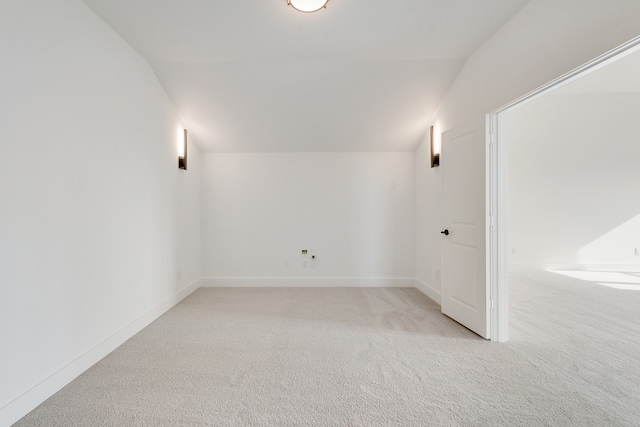 carpeted empty room featuring lofted ceiling