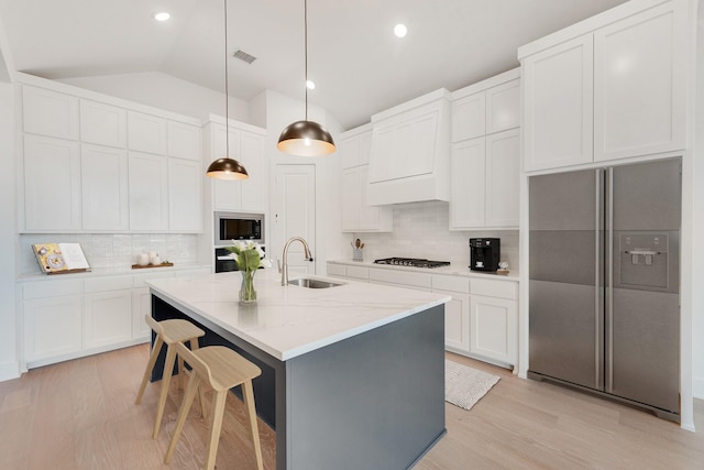 kitchen featuring hanging light fixtures, decorative backsplash, sink, and built in appliances