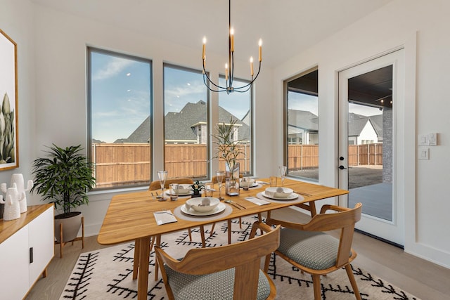 dining space with a notable chandelier and light hardwood / wood-style floors