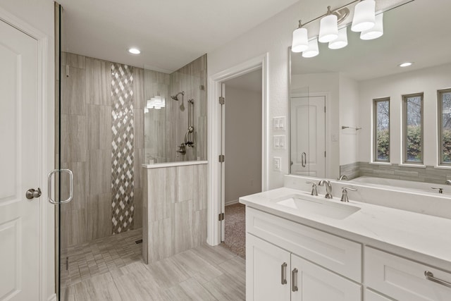 bathroom with a shower with shower door and vanity