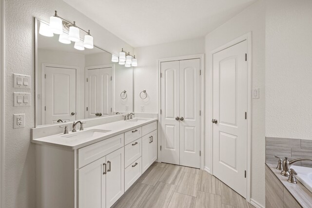 bathroom with a relaxing tiled tub and vanity