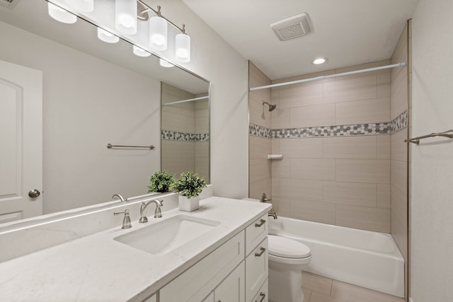 full bathroom featuring toilet, vanity, tiled shower / bath combo, and tile patterned floors