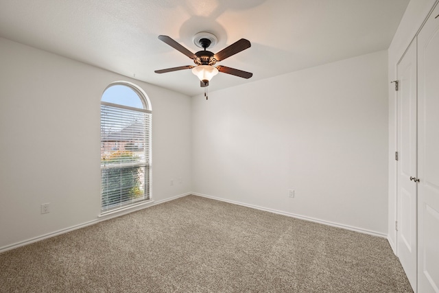 carpeted empty room featuring ceiling fan