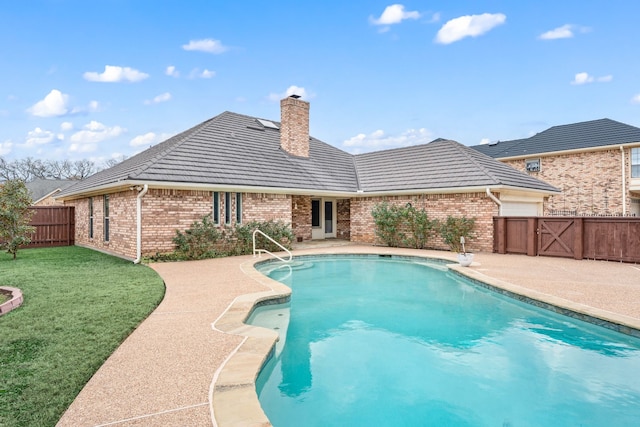 view of swimming pool with a patio area and a yard