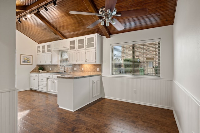 kitchen featuring wood ceiling, white cabinetry, rail lighting, sink, and lofted ceiling with beams