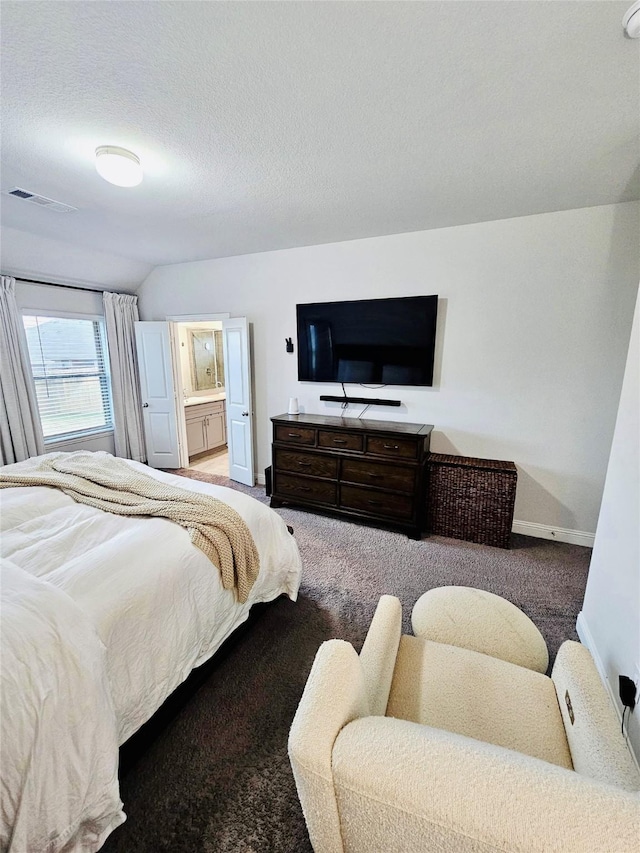 bedroom with lofted ceiling, carpet, connected bathroom, and a textured ceiling