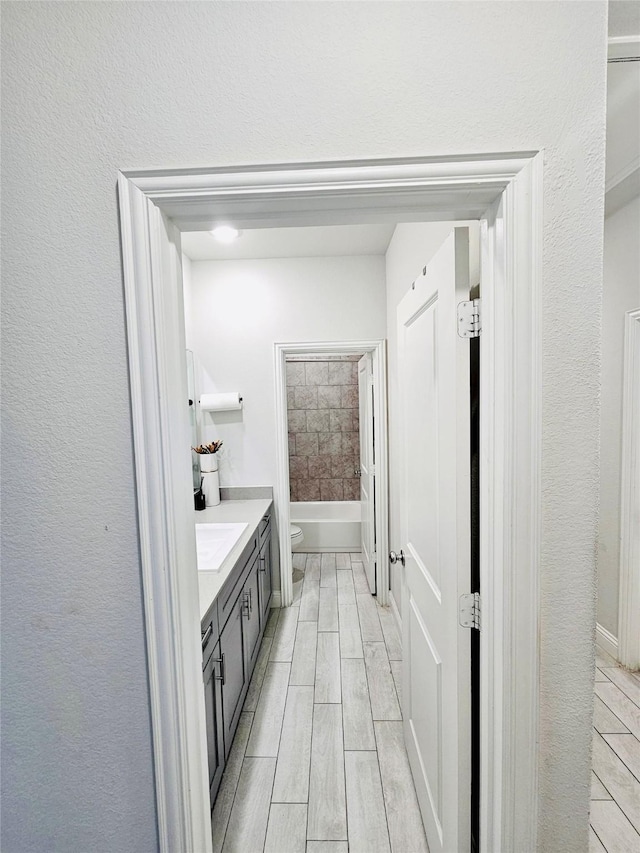 full bathroom with toilet, hardwood / wood-style floors, vanity, and bathtub / shower combination