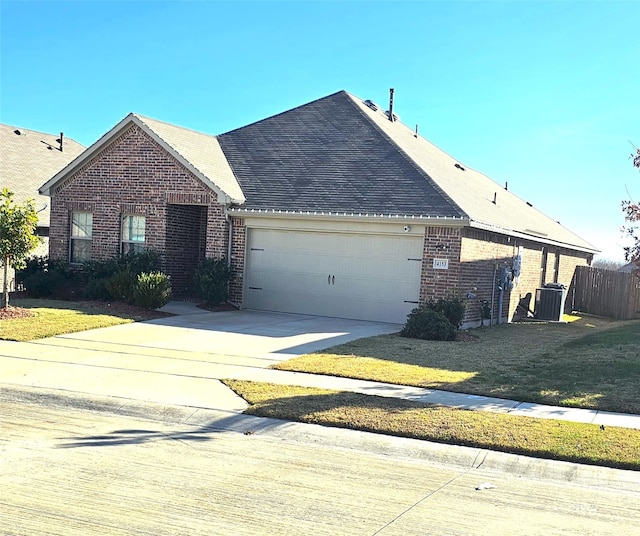 view of front facade featuring a front yard, central AC, and a garage