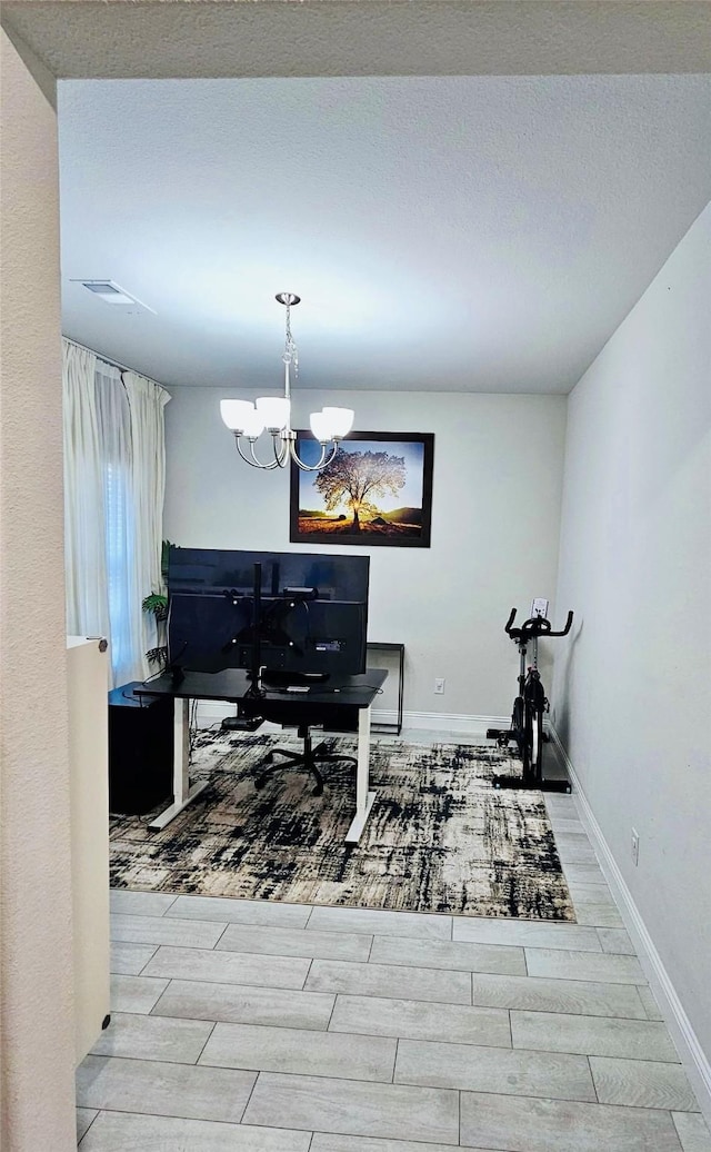 office space featuring light hardwood / wood-style floors, a textured ceiling, and a chandelier