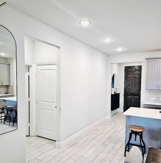 kitchen with backsplash, a kitchen breakfast bar, and gray cabinets