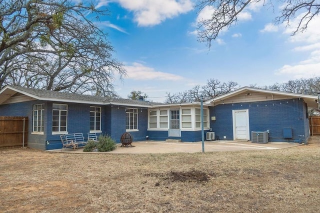 back of house featuring central AC unit, a patio area, and a yard