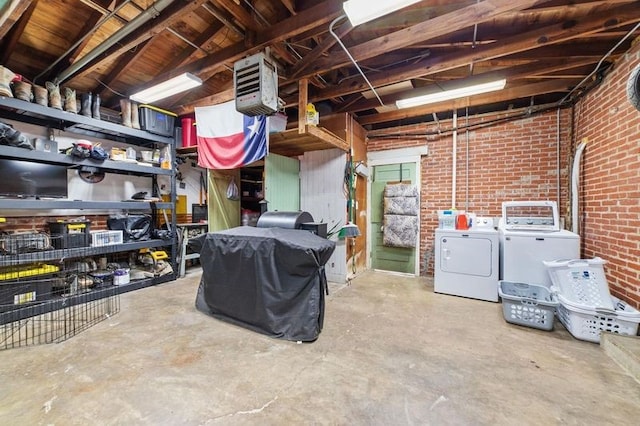 interior space with washing machine and dryer and brick wall