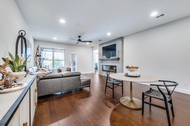 living room with ceiling fan, dark hardwood / wood-style flooring, and a fireplace