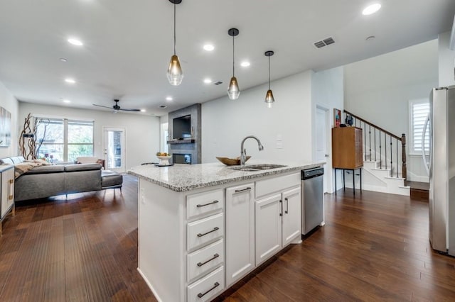 kitchen featuring sink, white cabinetry, a kitchen island with sink, light stone countertops, and stainless steel appliances