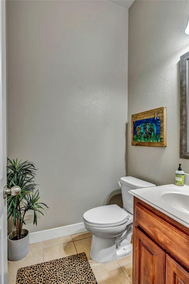 bathroom featuring toilet, vanity, and tile patterned flooring