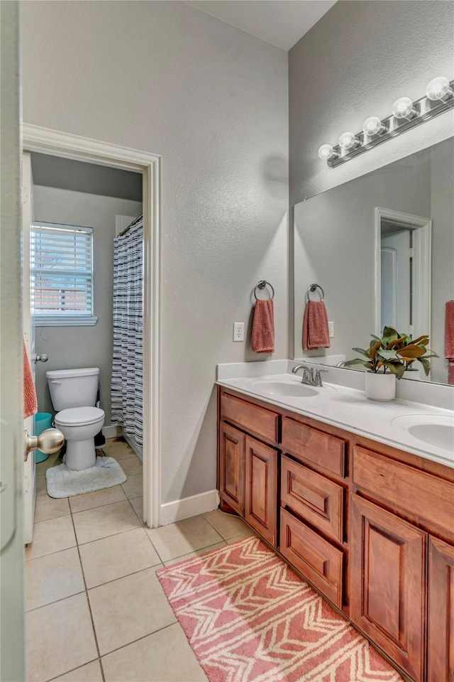 bathroom featuring toilet, vanity, and tile patterned flooring