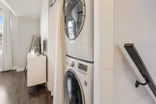 laundry area featuring dark hardwood / wood-style floors and stacked washer and dryer