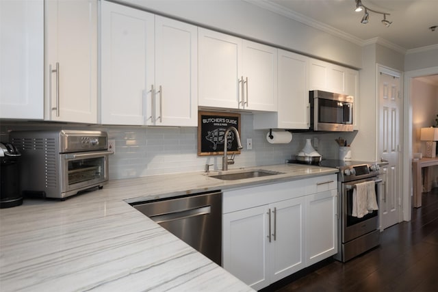 kitchen with sink, backsplash, white cabinets, light stone countertops, and stainless steel appliances