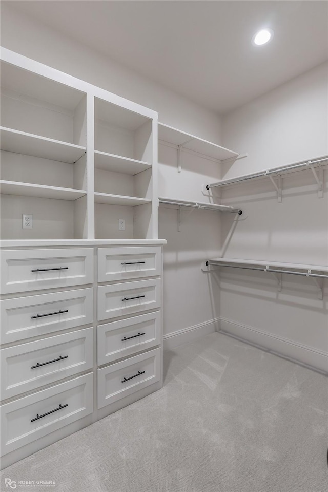 walk in closet with light colored carpet