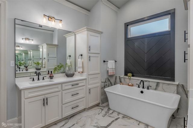 full bath featuring marble finish floor, a freestanding bath, and vanity