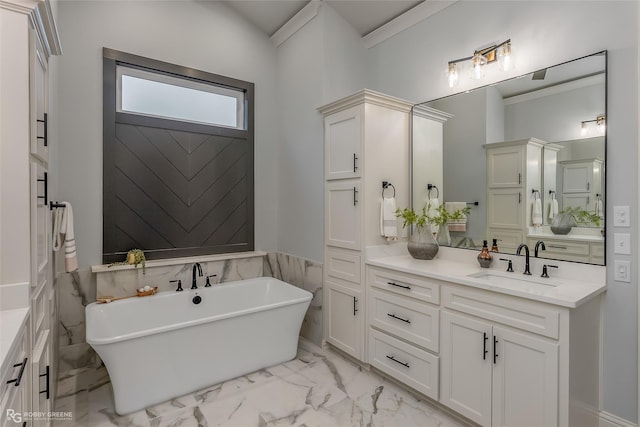 bathroom featuring marble finish floor, a freestanding bath, and vanity