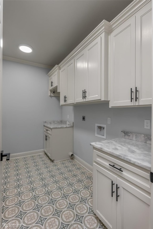 washroom with cabinet space, electric dryer hookup, baseboards, and light tile patterned floors