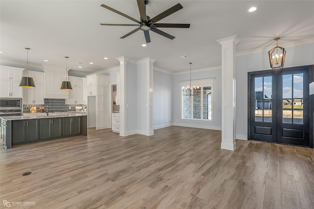 entrance foyer featuring baseboards, light wood finished floors, recessed lighting, and ornate columns