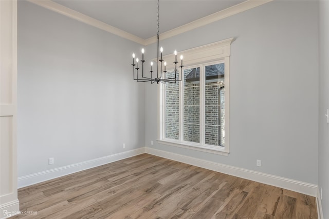 unfurnished dining area featuring light wood-style floors, a wealth of natural light, crown molding, and baseboards