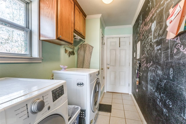 laundry room featuring cabinets, light tile patterned floors, ornamental molding, and independent washer and dryer