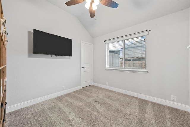 empty room with ceiling fan, carpet flooring, and vaulted ceiling