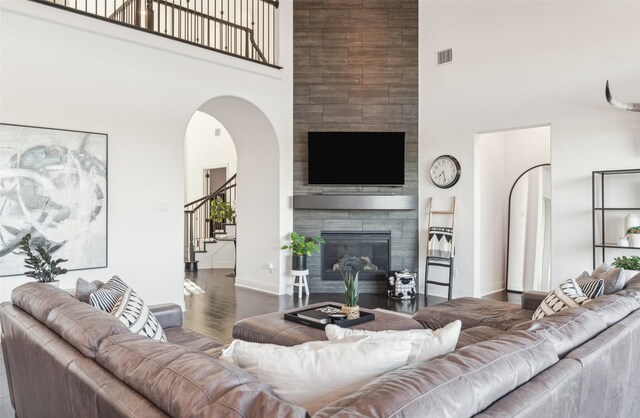 living room featuring a towering ceiling and dark hardwood / wood-style floors