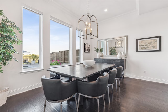 dining area featuring dark wood-type flooring, an inviting chandelier, ornamental molding, and a healthy amount of sunlight