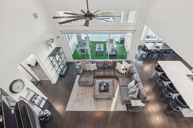 living room with ceiling fan, a high ceiling, and hardwood / wood-style flooring