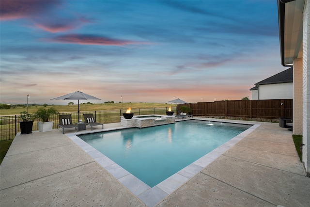 pool at dusk with a patio area