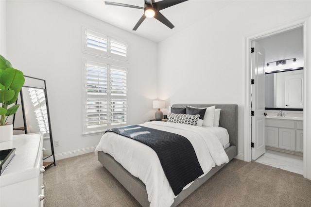 bedroom featuring connected bathroom, light carpet, a sink, and baseboards