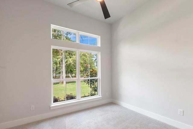 empty room featuring ceiling fan, carpet, and baseboards