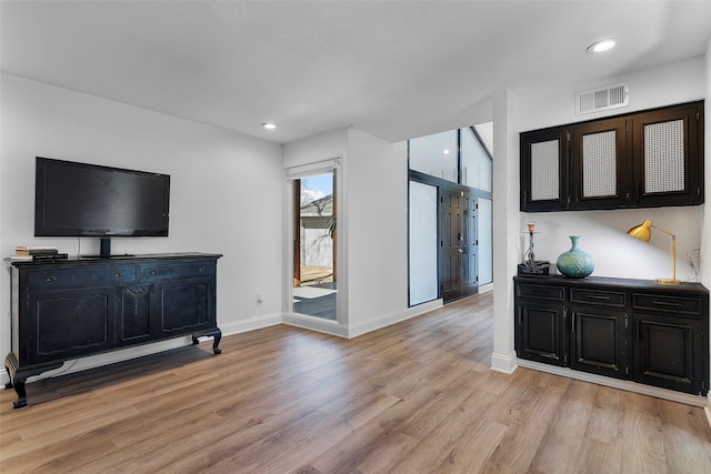 living area featuring recessed lighting, light wood-type flooring, visible vents, and baseboards